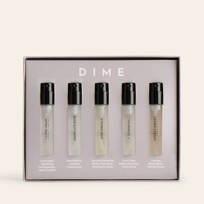 Five clear perfume sample vials with black spray caps in a branded box labeled "DIME."
