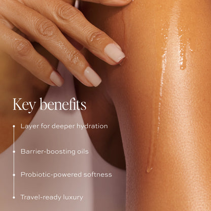 Hand touching glowing, moisturized skin with shimmer; manicured nails visible.