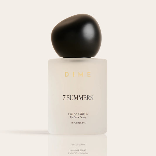 Round black cap atop cream-colored 7 Summers eau de parfum bottle labeled "DIME," 1.7 FL OZ size.