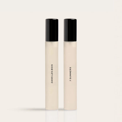 Two cylindrical fragrance bottles with black caps and cream-colored bodies labeled "Dawns Bows" and "7 Summers."