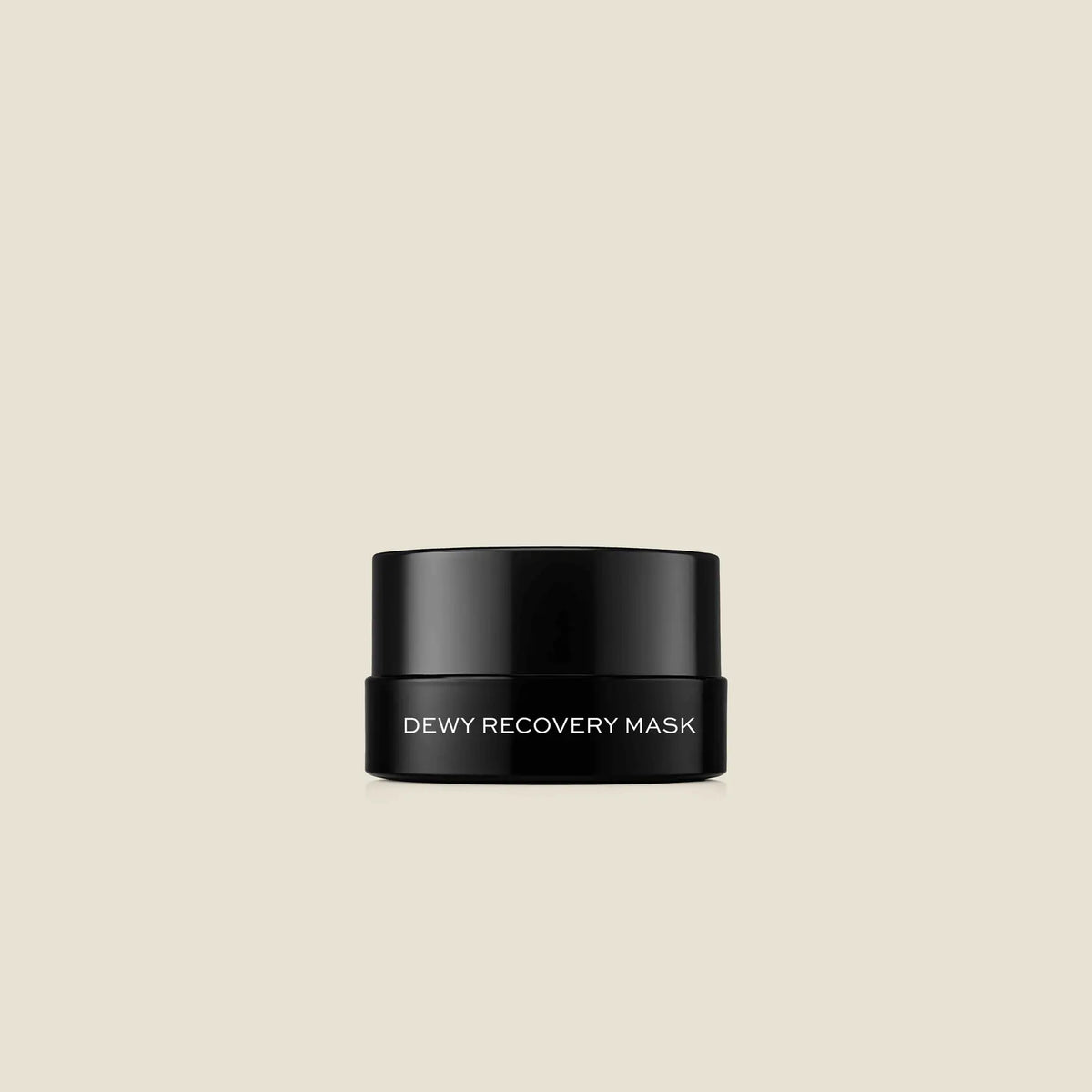 Black jar with white text reading "Dewy Recovery Mask" against a beige background.