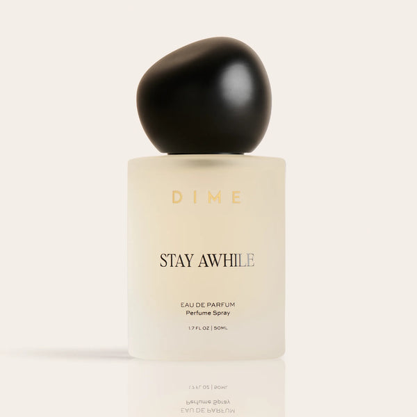 Cream-colored perfume bottle with black spherical cap labeled "Stay Awhile" eau de parfum spray, 1.7 fl oz.