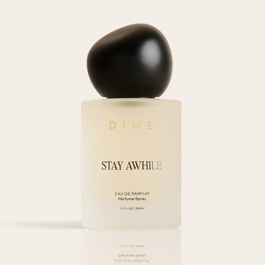 Cream-colored perfume bottle with black spherical cap labeled "Stay Awhile" eau de parfum spray, 1.7 fl oz.
