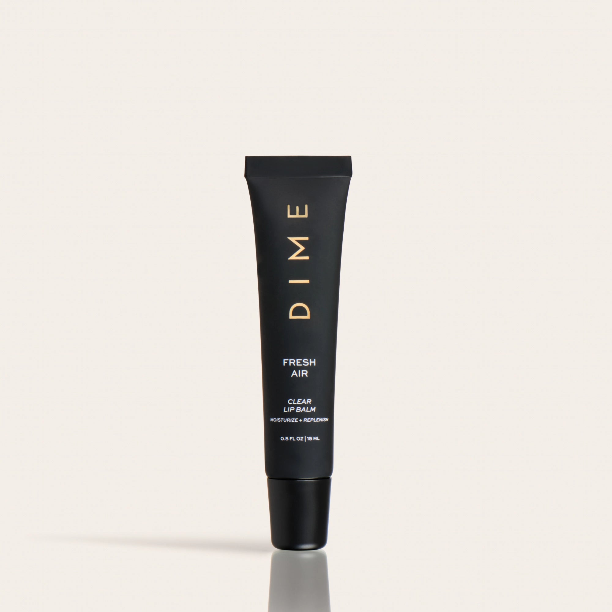 Black tube of DIME Fresh Air clear lip balm with gold lettering and black cap on neutral background.