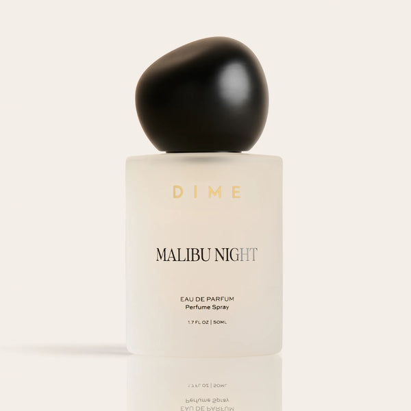 Cream-colored perfume bottle with black spherical cap labeled "Malibu Night" by Dime, 1.7 fl oz.