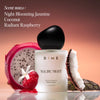 White cylindrical perfume bottle with black cap surrounded by dragon fruit, raspberry, jasmine flower, and coconut elements a
