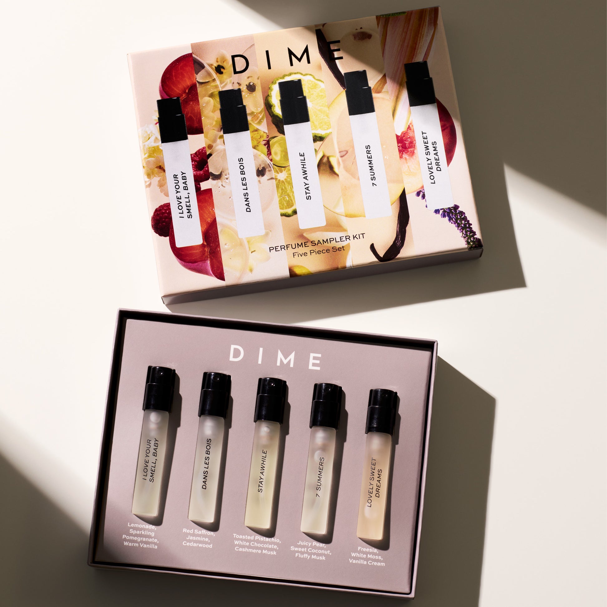 DIME perfume sampler kit with five spray bottles in white packaging with black caps, displayed in open box with floral design