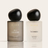 Two DIME fragrance bottles: left bottle in taupe labeled "NO.1 COLOGNE" with black spherical cap, right bottle in cream label
