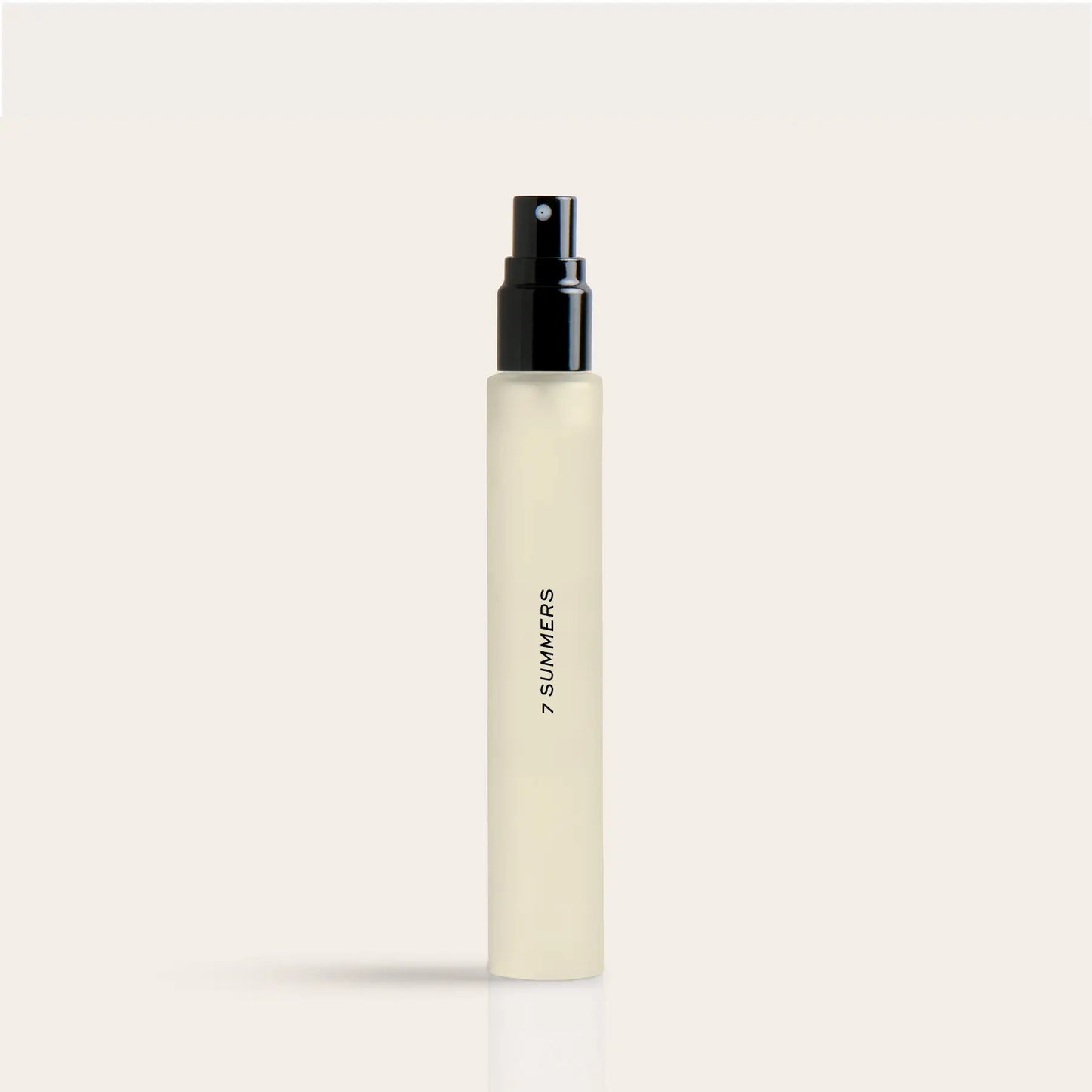 Cylindrical cream-colored perfume travel spray bottle with black spray top and "7 SUMMERS" text on side.