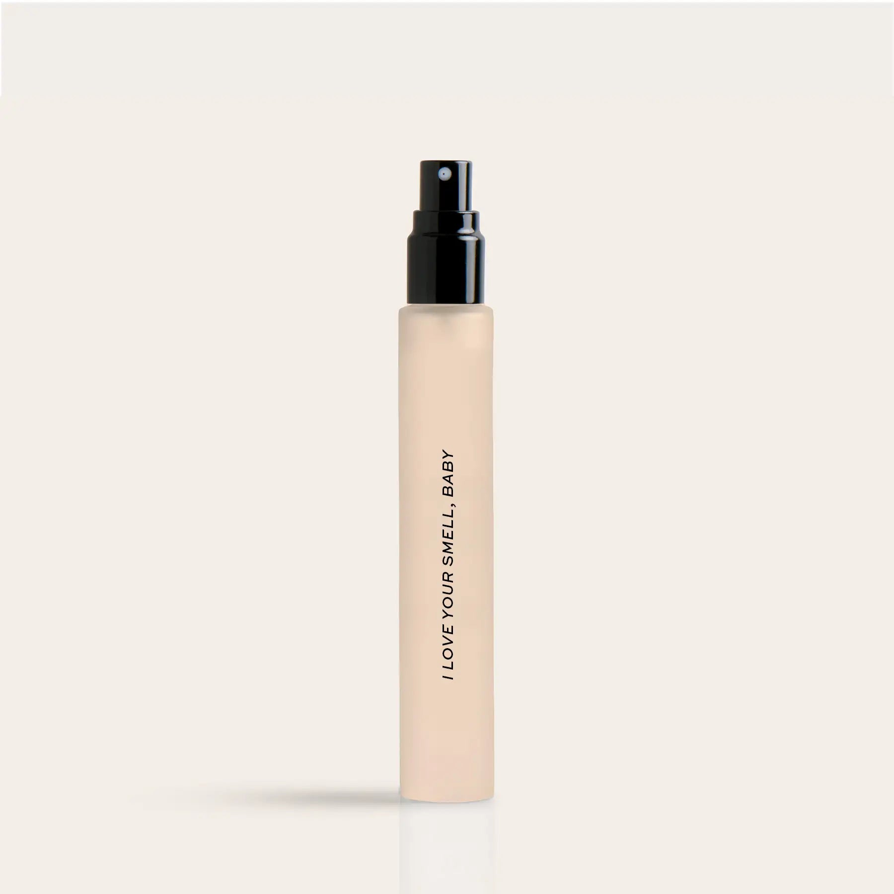 Cream-colored travel spray bottle with black pump top and "I LOVE YOUR SMELL BABY" text printed vertically on the bottle.